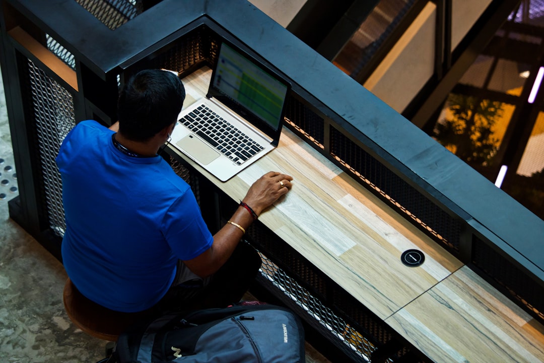 man-using-laptop-on-desk-mad2smykzu0